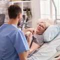 пожилая лежачая женщина и врач