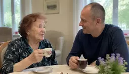 пожилая женщина и мужчина пьют чай